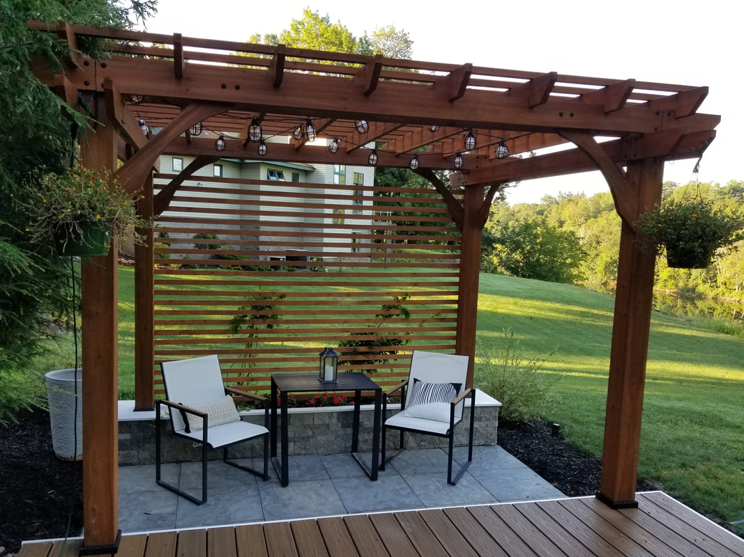 Cedar pergola over stamped concrete patio with hillside view
